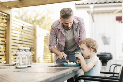 Father talking with son to have food at while standing at restaurant