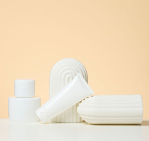 Plastic white container for cosmetics on a white table. jar and tuba, product demonstration and pr