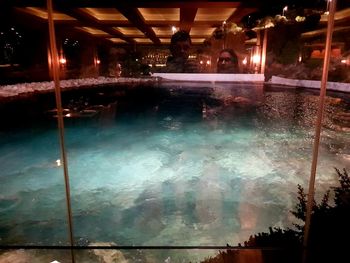 Reflection of illuminated glass window in restaurant at night