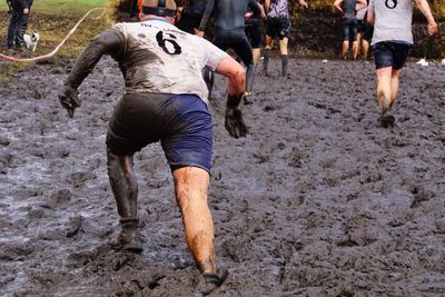 Low section of man standing on mud