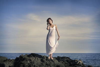Woman in white dress by the sea