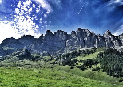 Scenic view of mountains against cloudy sky