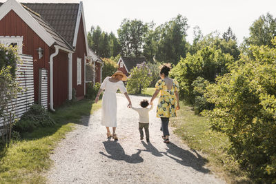 Toddler walking with mother and grandmother