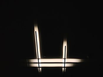 Low angle view of illuminated lamp in darkroom