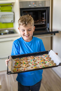 Smiling boy holding baking tray