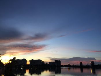Silhouette buildings against sky at sunset