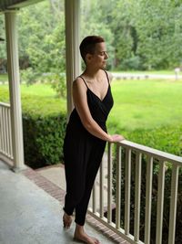 Young woman standing by railing