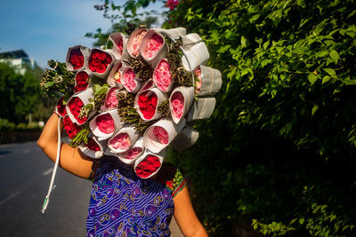 Midsection of woman holding bouquet of red rose