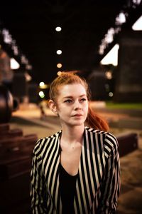 Portrait of beautiful woman standing at night