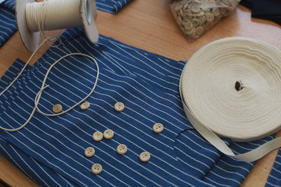 High angle view of blue cloth with sewing items on table