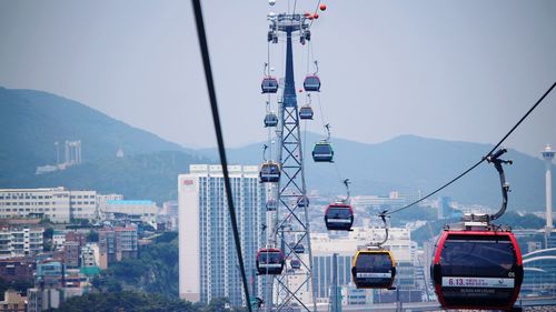 Overhead cable cars in city against clear sky