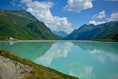 Idyllic view of mountains and calm lake against cloudy sky