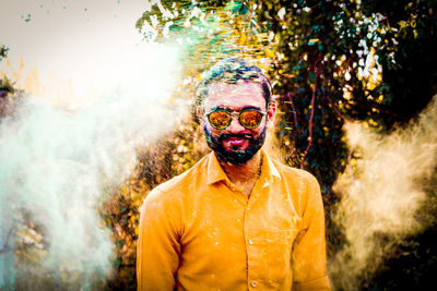 Portrait of young man wearing sunglasses standing outdoors