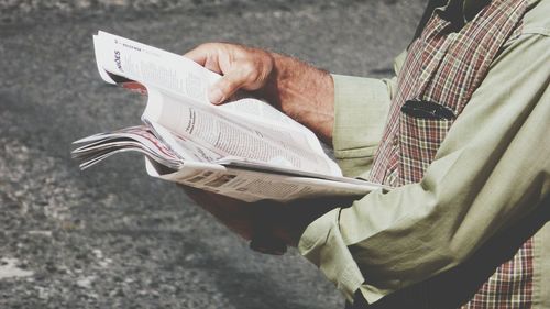 Low section of man holding book