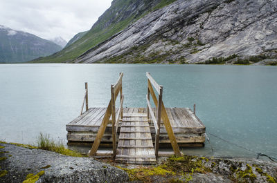 Wooden structure by lake against sky