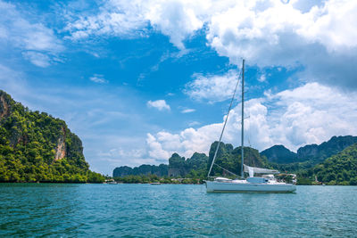 Sailboats sailing in sea against sky