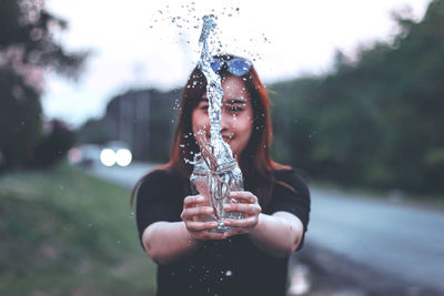 Portrait of woman drinking water