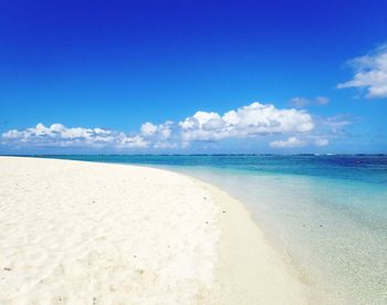 Scenic view of beach against blue sky