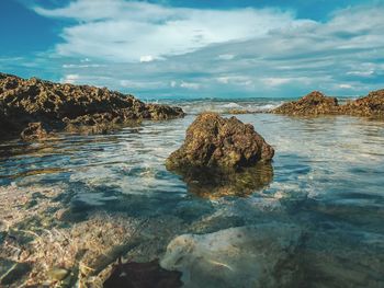 Rocks on beach against sky