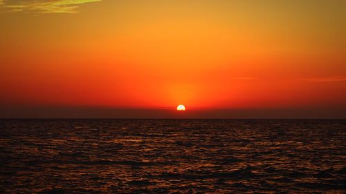 Scenic view of sea against orange sky