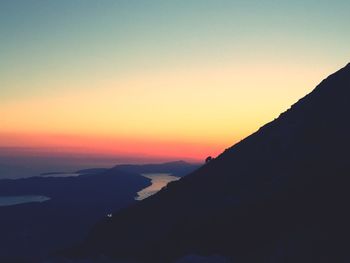 Scenic view of silhouette mountains against clear sky during sunset