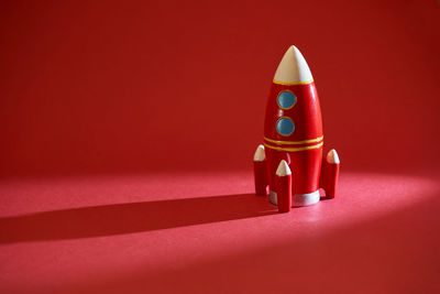 Close-up of figurine on table against red background