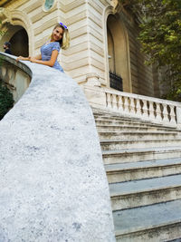 Low angle view of woman standing by staircase outside building