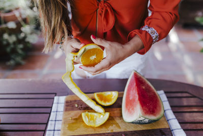 Midsection of woman holding fruits on table