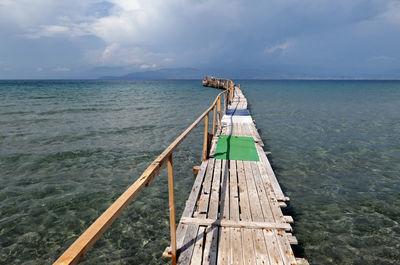 Jetty over sea against sky