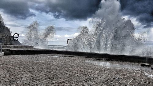 Water splashing on street against sky