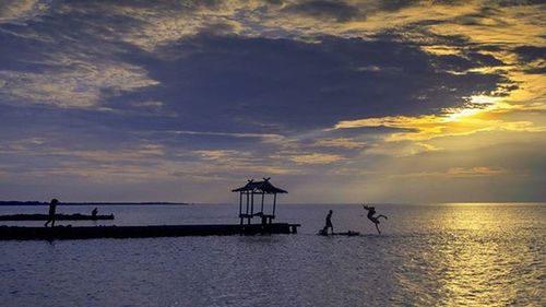 Scenic view of sea against cloudy sky at sunset