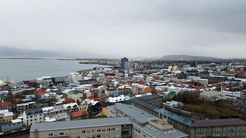 High angle view of cityscape by sea against sky