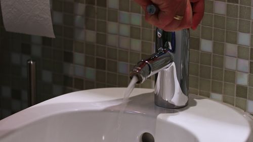 Midsection of woman in bathroom at home