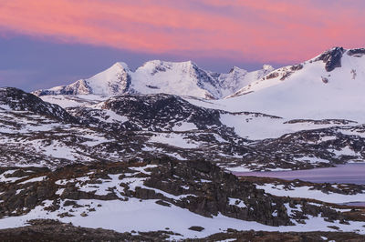 Pink sky above snow covered mountain scenery