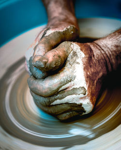 Close-up of human hands making pottery