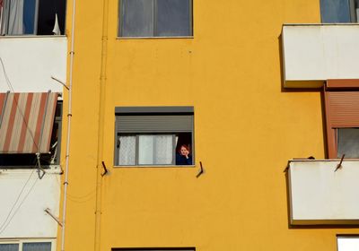 Low angle view of woman at window of building