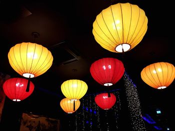 Low angle view of illuminated lanterns hanging at night