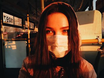 Close-up of woman wearing mask while traveling in bus