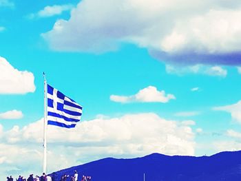 Low angle view of flag against blue sky