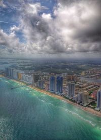 View of cityscape against cloudy sky