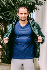 Portrait of man wearing jacket standing outdoors