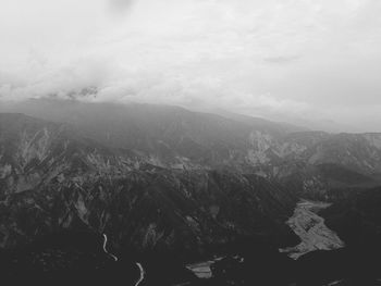 Scenic view of mountains against cloudy sky