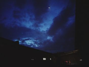 Low angle view of silhouette buildings against sky at night