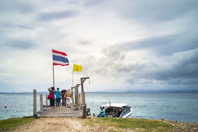 People on beach by sea against sky