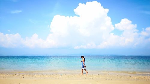Full length of man standing on beach against sky