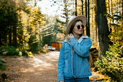 Portrait of man wearing sunglasses standing in forest