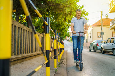Man riding push scooter on street