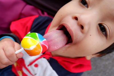 High angle view of boy licking lollipop