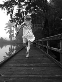 Rear view of woman walking on boardwalk