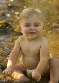 Portrait of smiling boy sitting outdoors